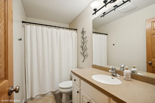 bathroom with vanity, hardwood / wood-style floors, a textured ceiling, and toilet