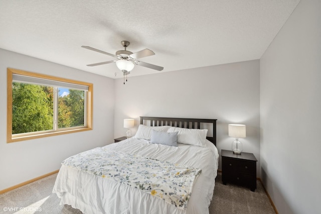 carpeted bedroom with ceiling fan and a textured ceiling