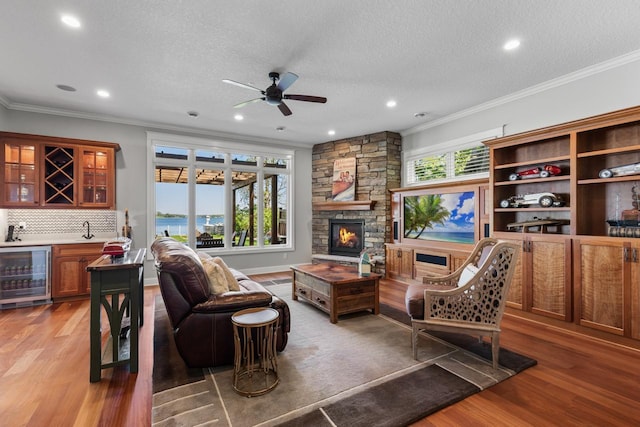 2172 Shadywood Rd, Orono, MN 55391 - living area with wine cooler, bar with sink, ceiling fan, ornamental molding, and light wood-style floors
