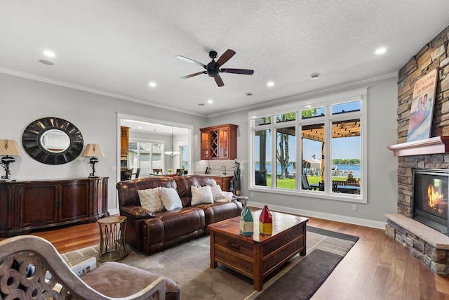 2172 Shadywood Rd, Orono, MN 55391 - living room featuring a ceiling fan, wood finished floors, a stone fireplace, recessed lighting, and crown molding