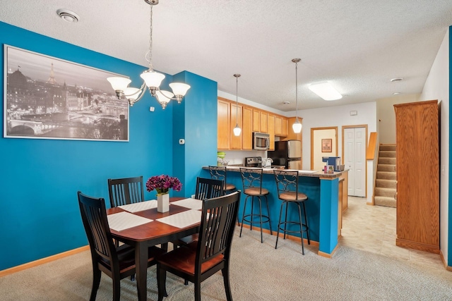 dining room with light carpet, an inviting chandelier, and a textured ceiling