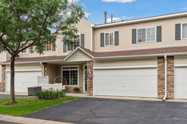 multi unit property featuring central AC unit and a garage