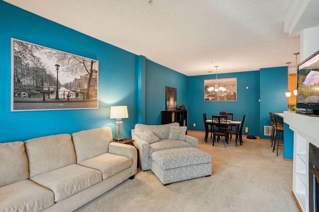 living room featuring carpet floors, a textured ceiling, and a notable chandelier