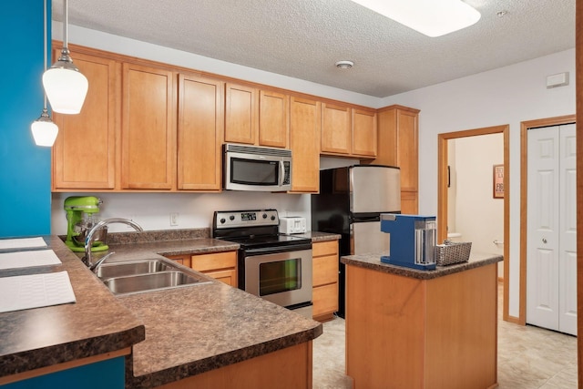 kitchen with a textured ceiling, stainless steel appliances, hanging light fixtures, and sink