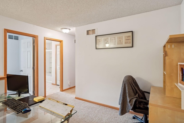 office with light colored carpet and a textured ceiling