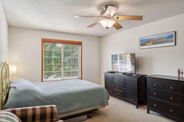 carpeted bedroom featuring ceiling fan and a textured ceiling