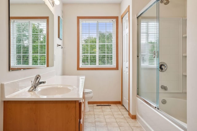 full bathroom featuring tile patterned flooring, shower / bath combination with glass door, vanity, and toilet