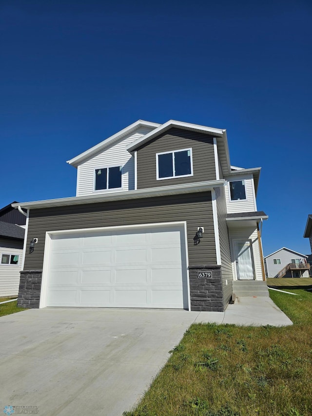 view of front of property with a garage and a front lawn