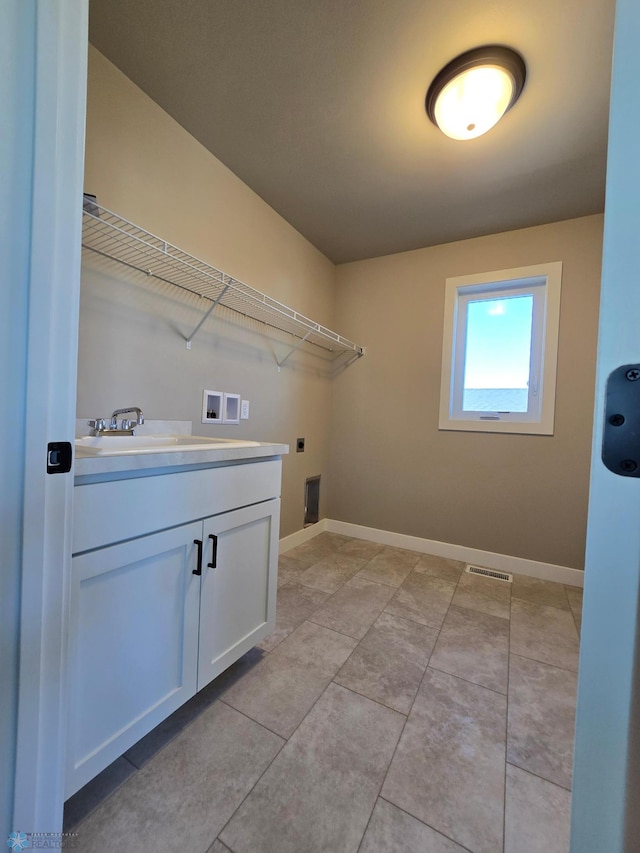 laundry area featuring washer hookup, light tile patterned floors, sink, cabinets, and electric dryer hookup