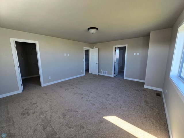 6379 83rd Ave S, Fargo, ND 58047 - unfurnished bedroom featuring a closet, light colored carpet, a walk in closet, and ensuite bath
