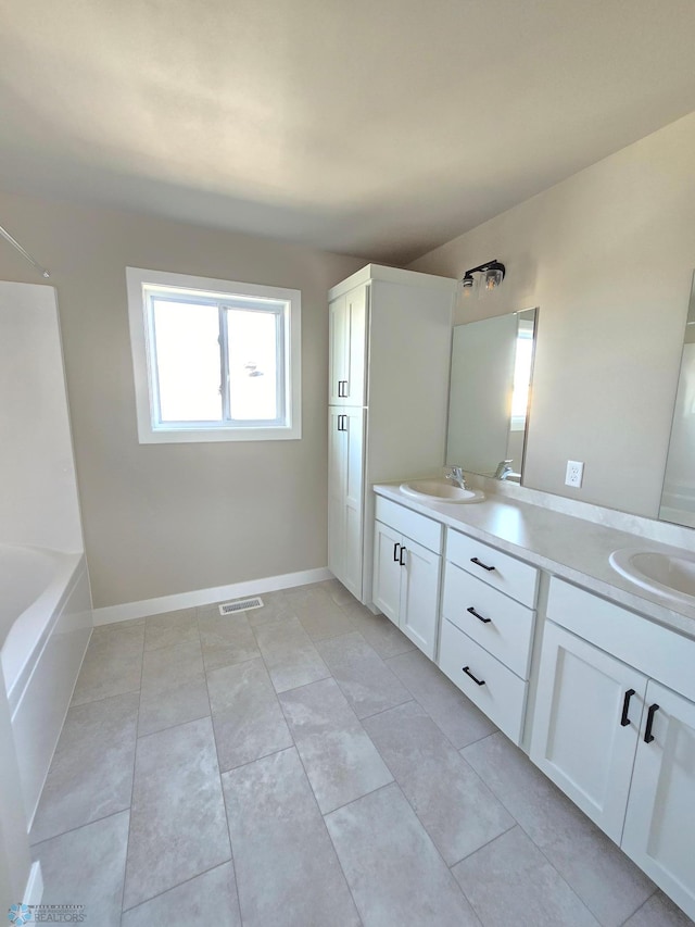 6379 83rd Ave S, Fargo, ND 58047 - bathroom featuring tile patterned floors, a bathing tub, and vanity