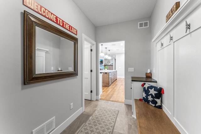 mudroom with hardwood / wood-style floors and a chandelier