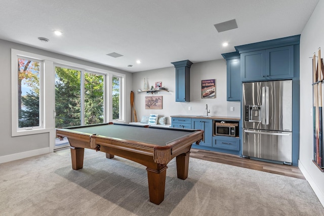 game room with indoor wet bar, light hardwood / wood-style floors, and pool table