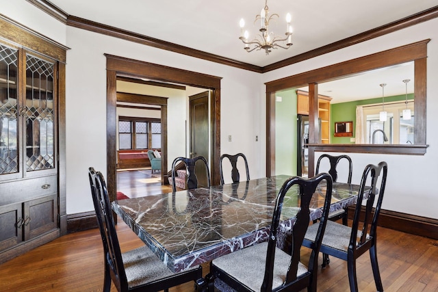 dining space featuring crown molding, dark hardwood / wood-style flooring, plenty of natural light, and an inviting chandelier