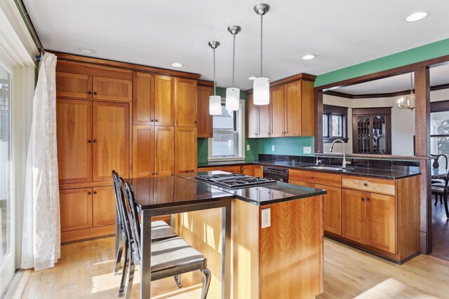 kitchen with light wood-type flooring, decorative light fixtures, a kitchen island, and an inviting chandelier