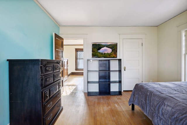 bedroom with crown molding and light hardwood / wood-style flooring