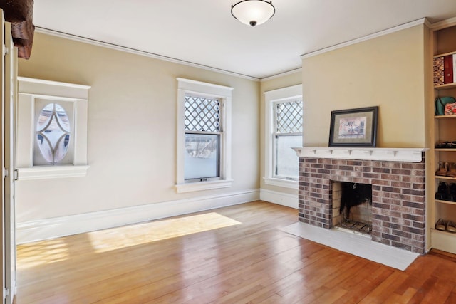 living room featuring a fireplace, ornamental molding, and light wood-type flooring