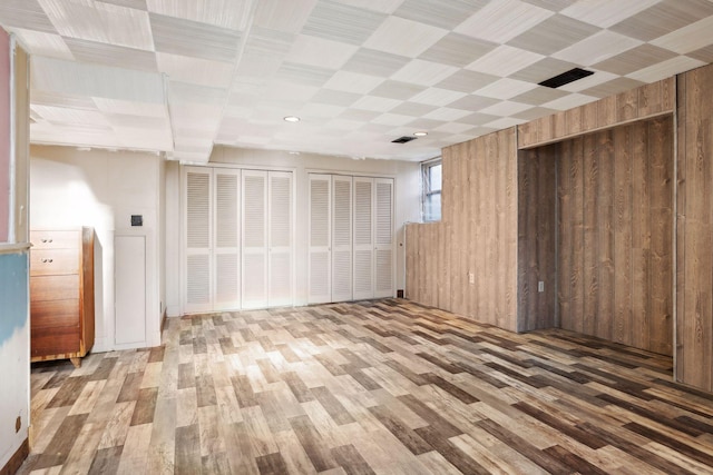 basement featuring wood walls and wood-type flooring