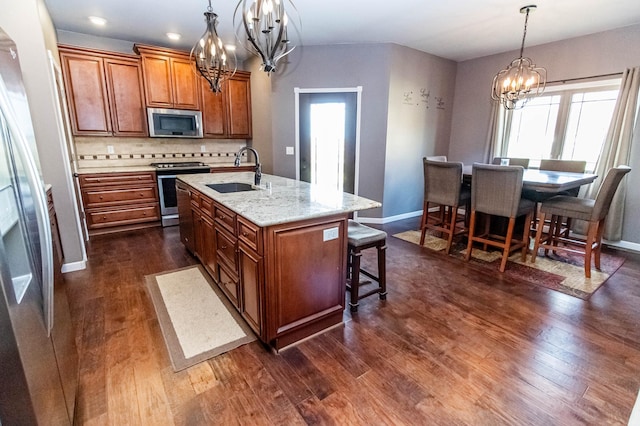 kitchen featuring appliances with stainless steel finishes, a center island with sink, plenty of natural light, and sink