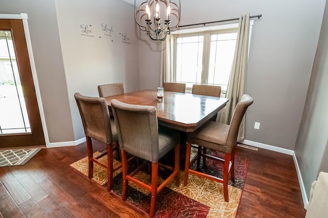 dining space featuring dark hardwood / wood-style floors and a notable chandelier