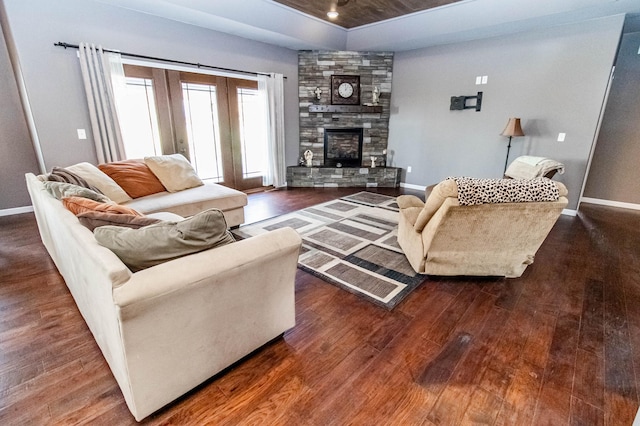 living room with a fireplace and dark wood-type flooring