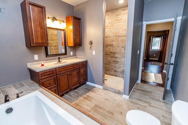 full bathroom featuring hardwood / wood-style flooring, vanity, independent shower and bath, and toilet