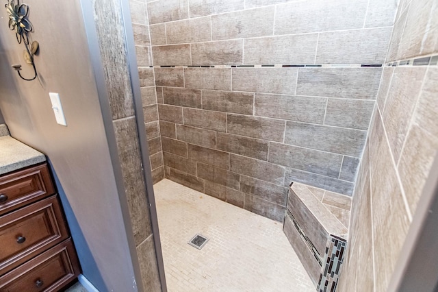 bathroom with vanity and tiled shower