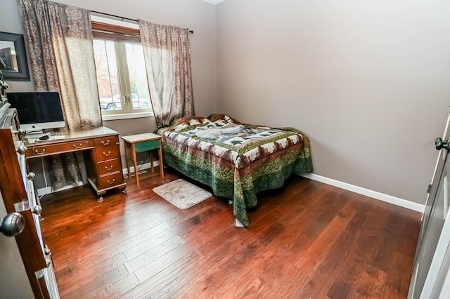 bedroom with dark hardwood / wood-style flooring