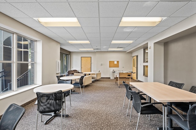 dining space featuring a drop ceiling and carpet floors