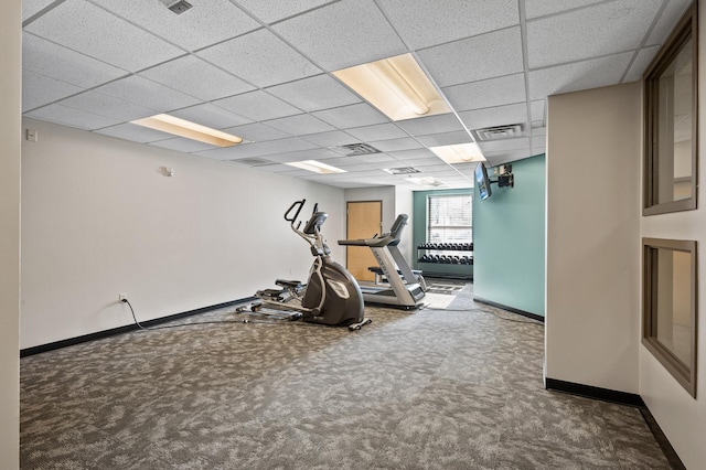 exercise area with carpet floors and a paneled ceiling