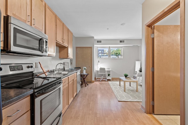 kitchen featuring light brown cabinetry, sink, appliances with stainless steel finishes, and light wood-type flooring