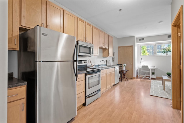 kitchen featuring light brown cabinetry, sink, light hardwood / wood-style flooring, and stainless steel appliances