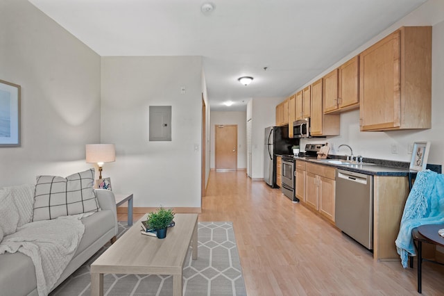 kitchen with sink, light hardwood / wood-style floors, stainless steel appliances, electric panel, and light brown cabinets