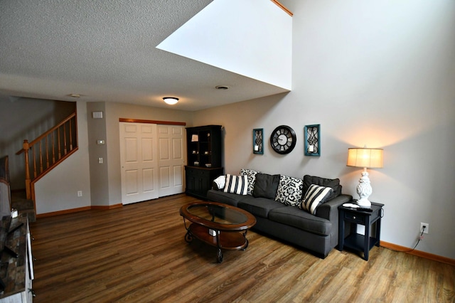 living room featuring wood-type flooring and a textured ceiling