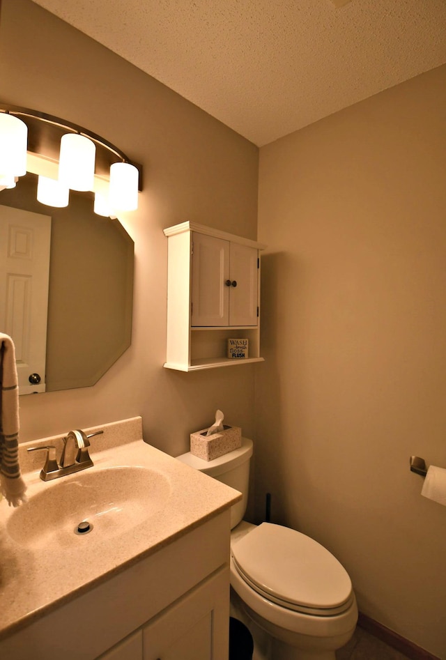 bathroom with vanity, toilet, and a textured ceiling