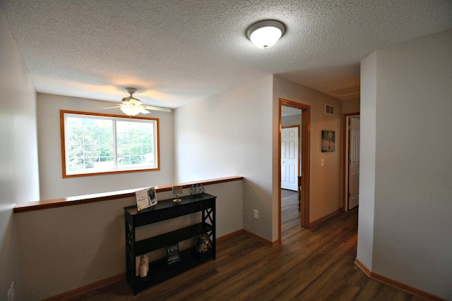 hallway featuring dark hardwood / wood-style flooring and a textured ceiling