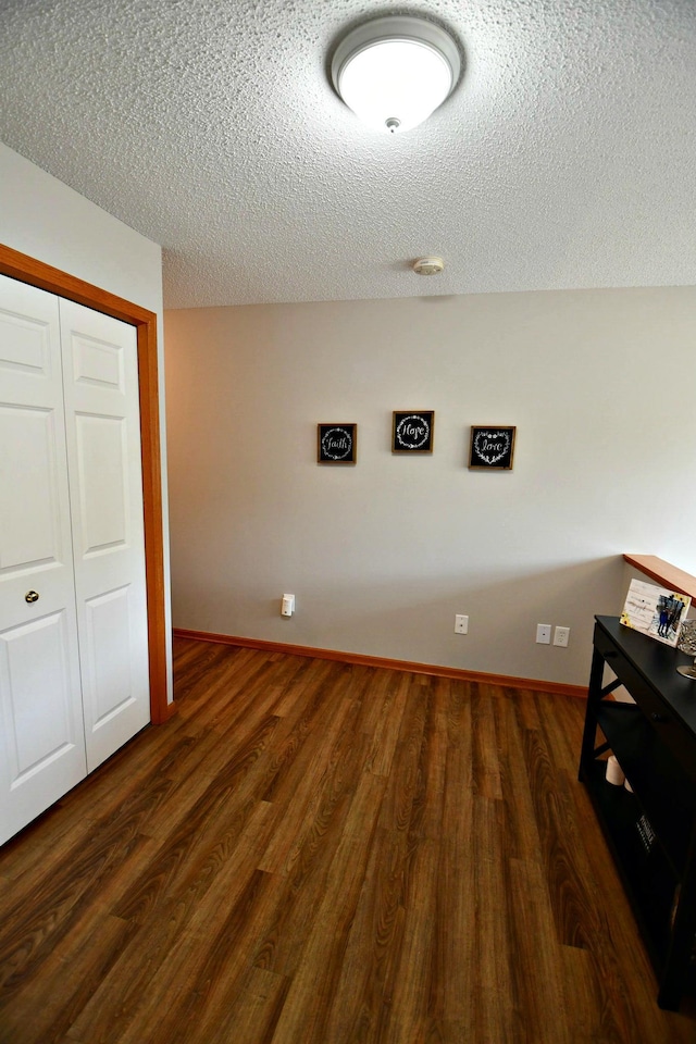 laundry room with a textured ceiling and dark hardwood / wood-style floors