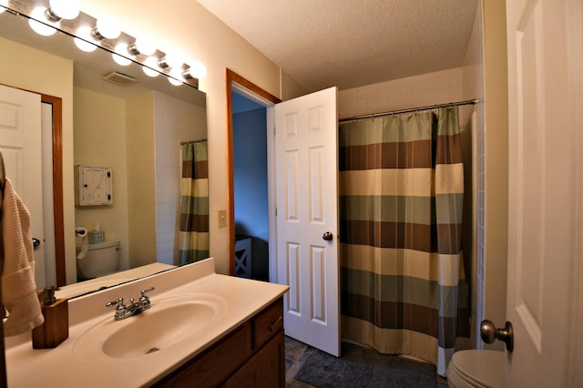 bathroom with walk in shower, vanity, toilet, and a textured ceiling