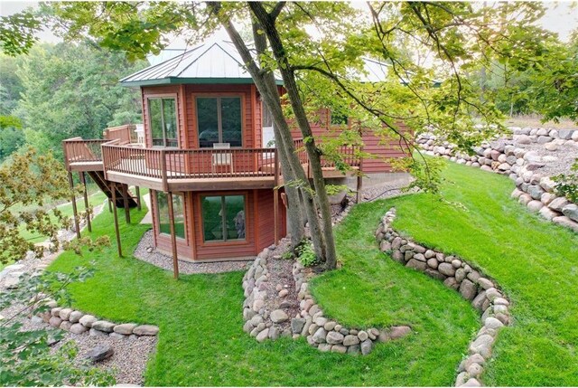 back of property with a lawn and a wooden deck