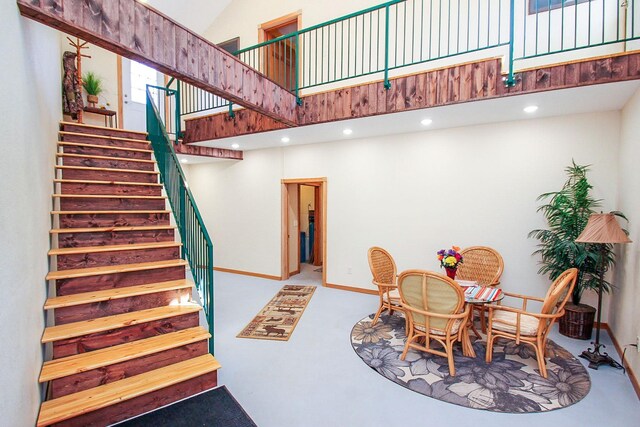 staircase featuring high vaulted ceiling