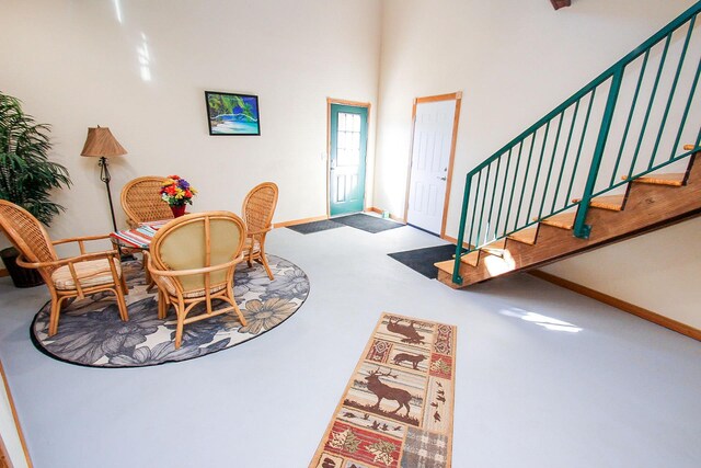 carpeted foyer featuring a towering ceiling