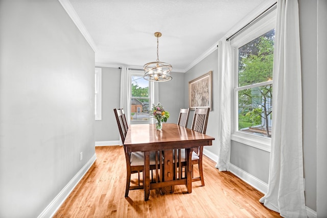 4512 47th Ave S, Minneapolis, MN 55406 - dining space with crown molding, a chandelier, light wood-style flooring, and baseboards