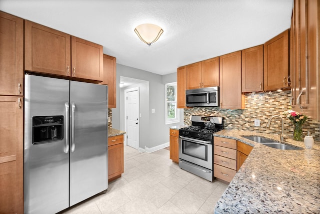 4512 47th Ave S, Minneapolis, MN 55406 - kitchen featuring stainless steel appliances, a sink, baseboards, tasteful backsplash, and light stone counters