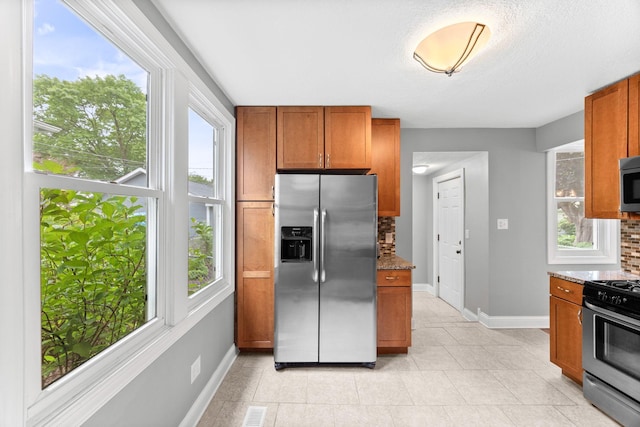 4512 47th Ave S, Minneapolis, MN 55406 - kitchen with stainless steel appliances, brown cabinets, baseboards, and stone counters