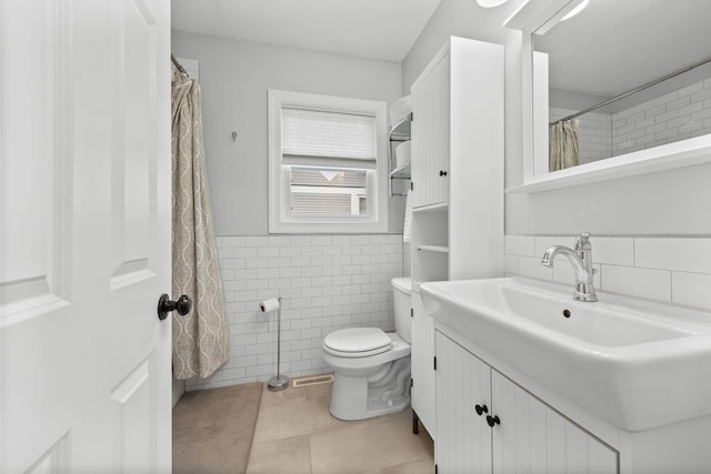 4512 47th Ave S, Minneapolis, MN 55406 - bathroom featuring tile walls, vanity, toilet, tile patterned flooring, and a wainscoted wall