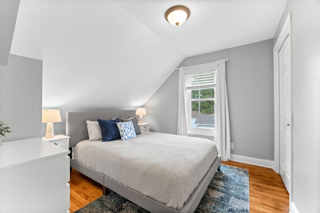 4512 47th Ave S, Minneapolis, MN 55406 - bedroom featuring light wood-style floors, lofted ceiling, a textured ceiling, and baseboards