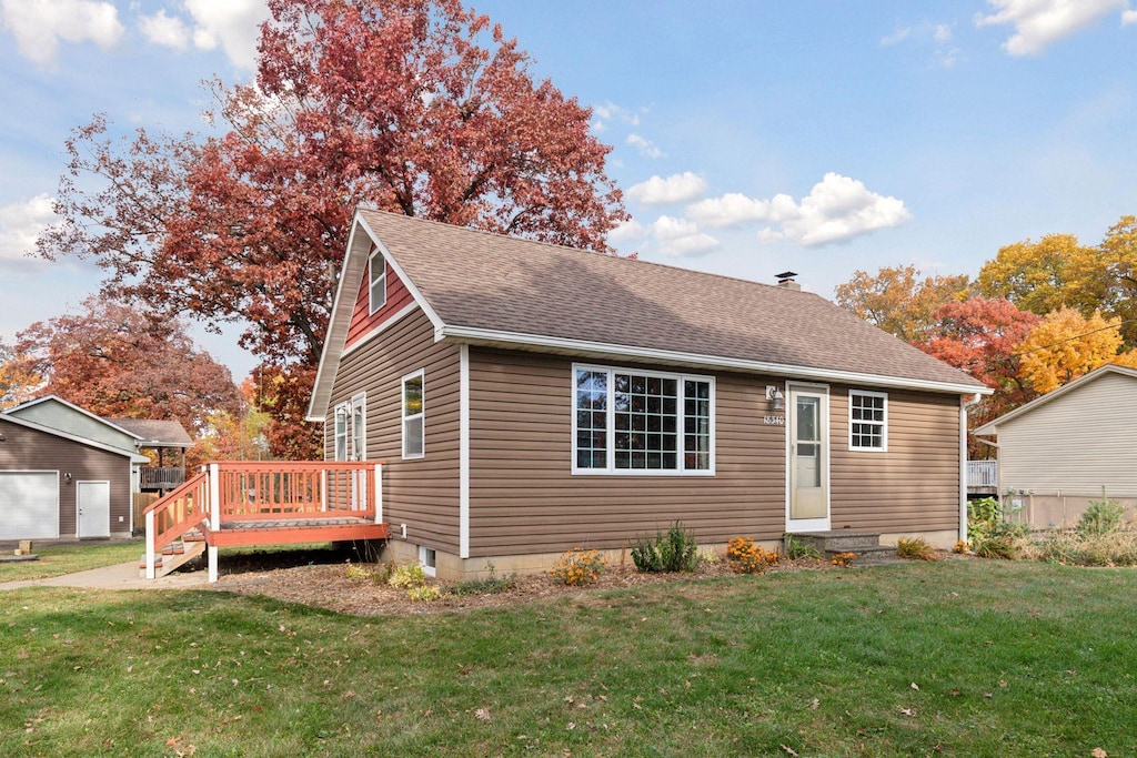 view of front of house with a wooden deck and a front lawn