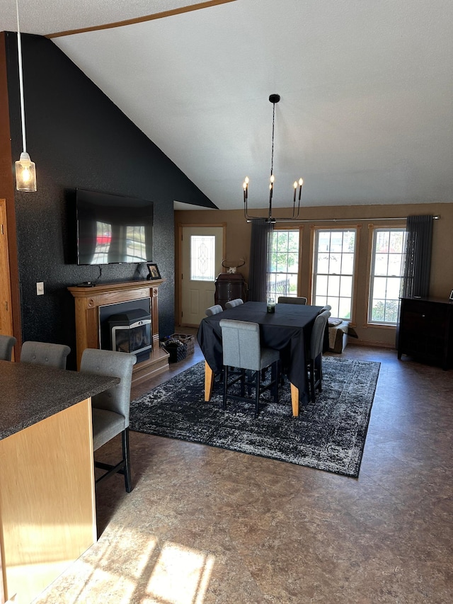 dining space featuring a wood stove, a notable chandelier, and vaulted ceiling