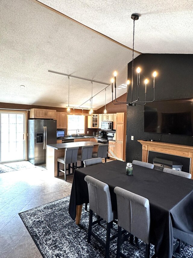 dining space featuring vaulted ceiling, sink, and a textured ceiling