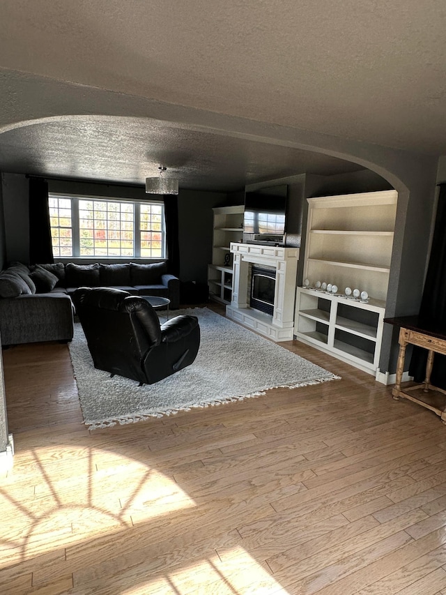 living room featuring wood-type flooring and a textured ceiling